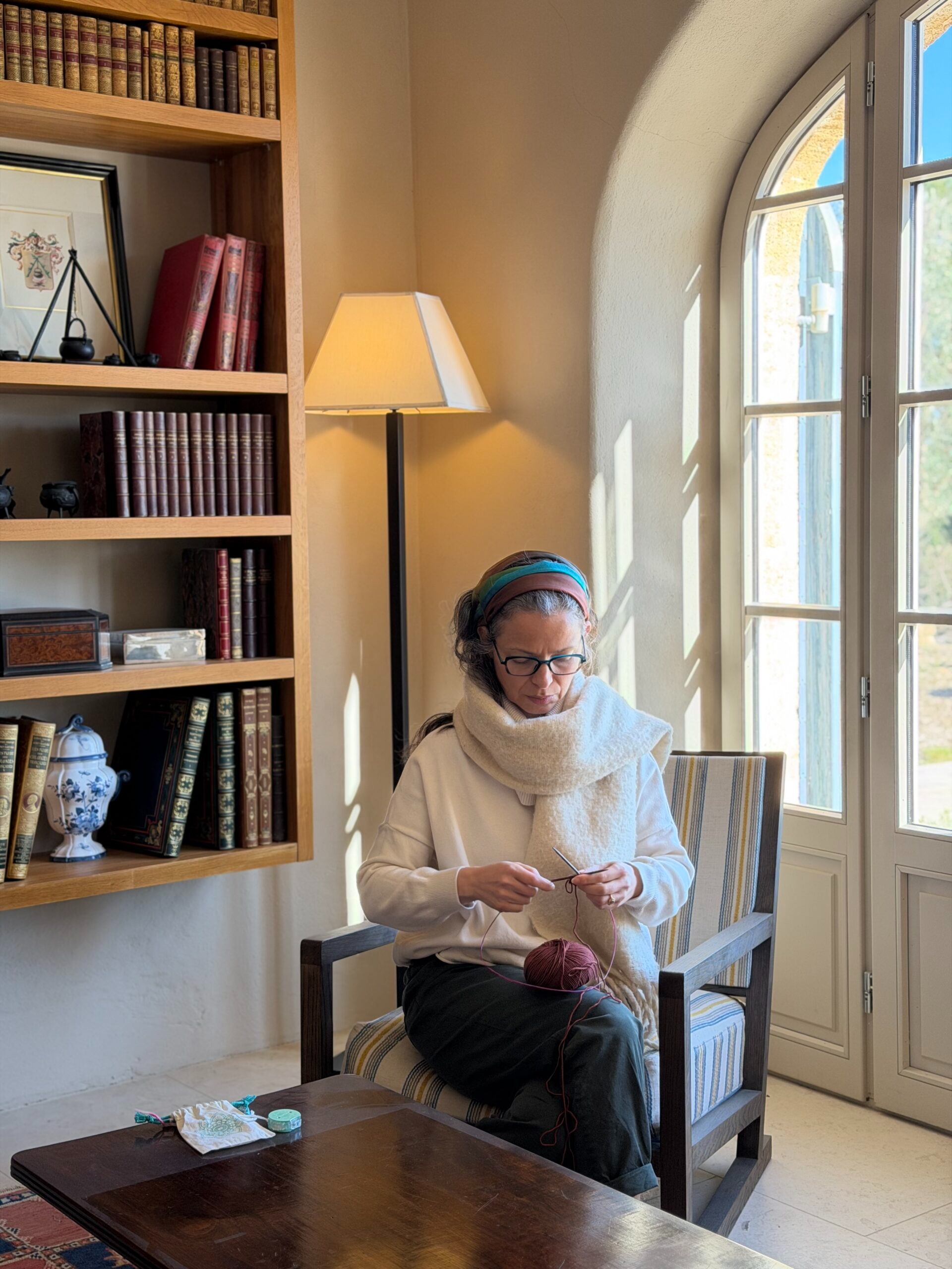 Woman sitting in a chair while knitting.