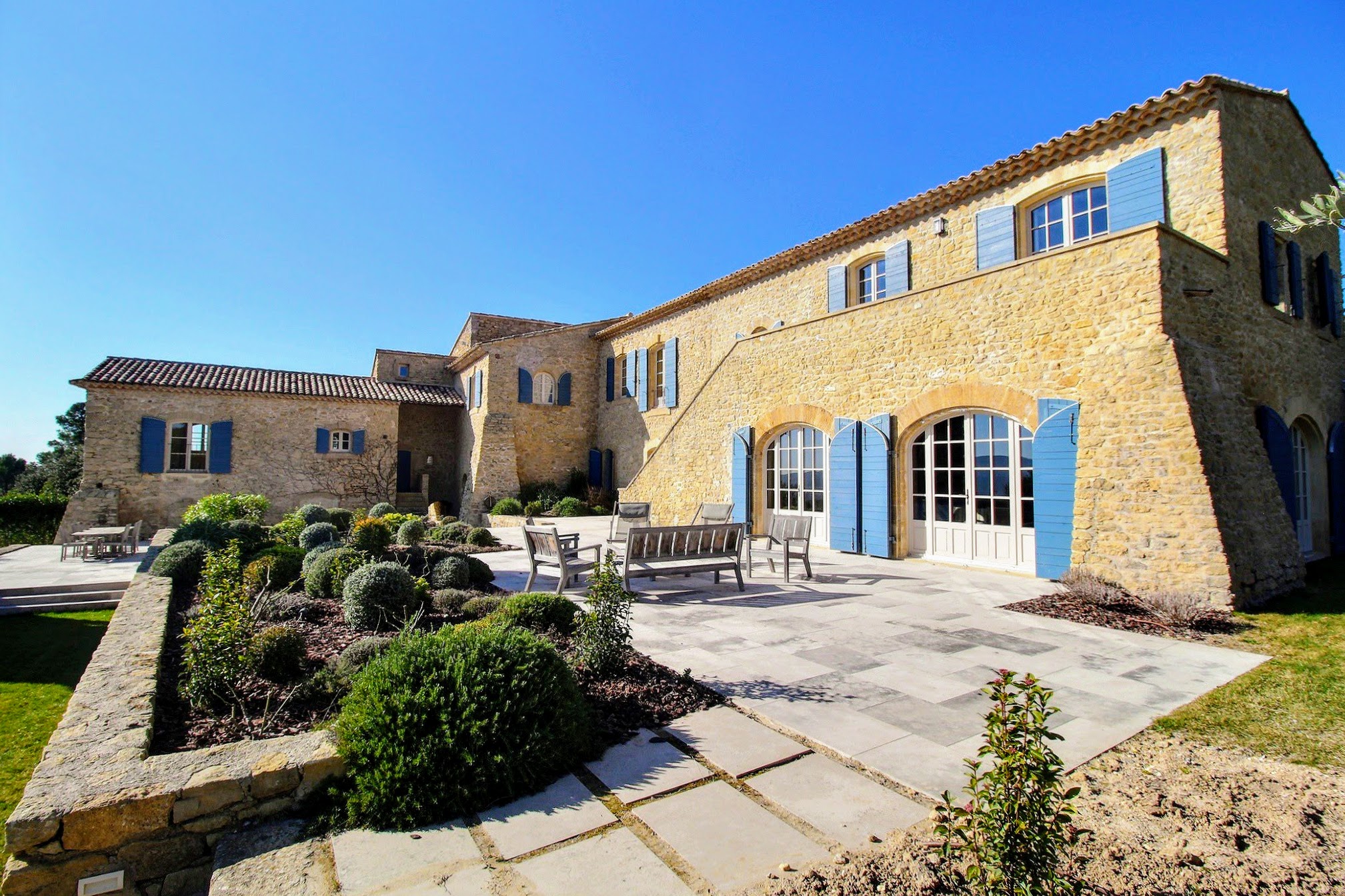 A view of the property's lounging area with multiple chairs oriented in a circle and a view of the back of the property.