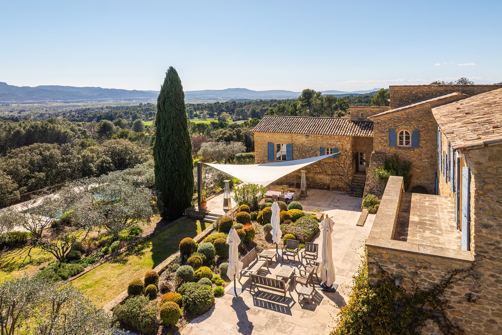 An upper view of the property where the yard, sitting area, and upper balcony area are visible.