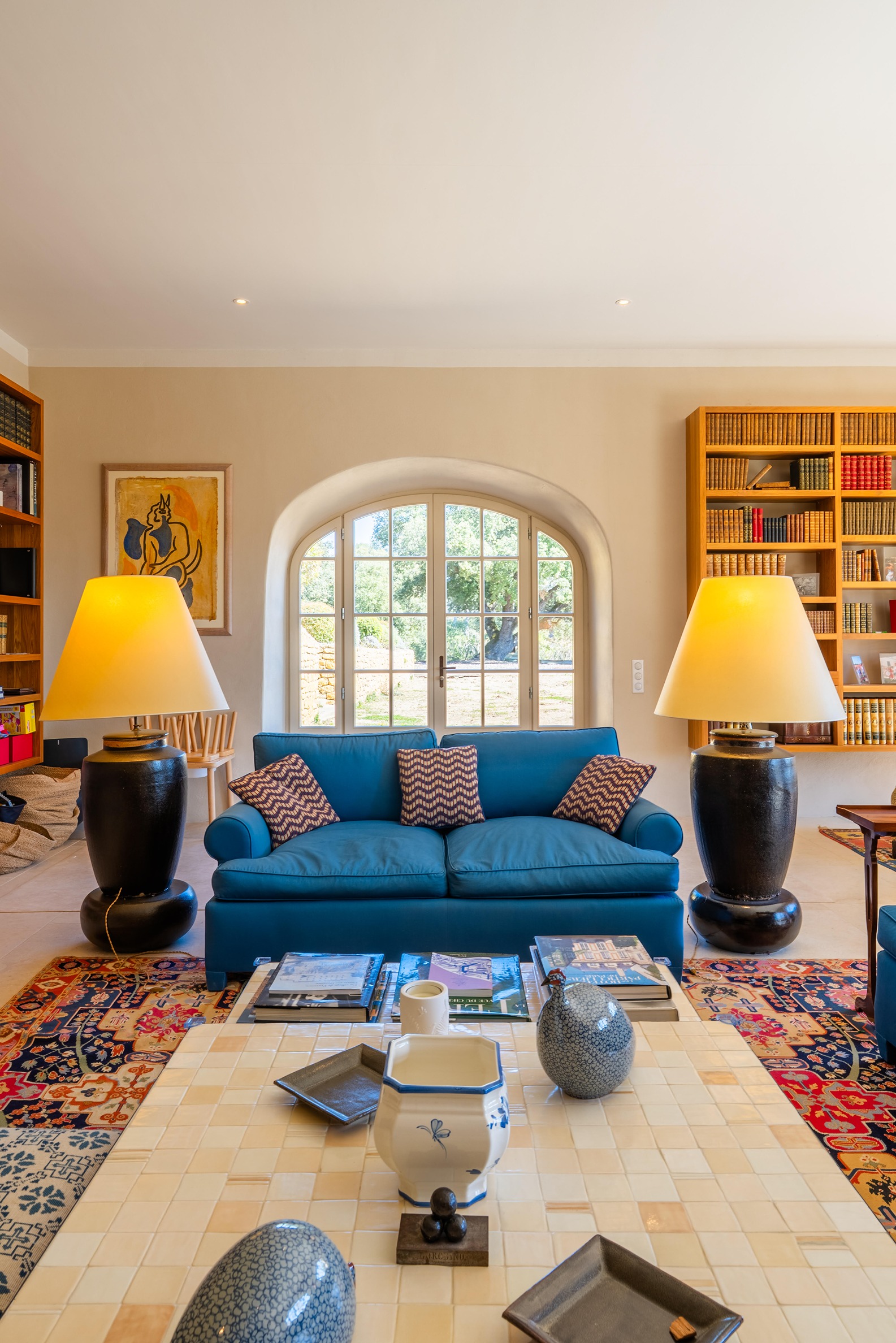 Stylish sitting room with a blue couch and two large standing lamps on either side.