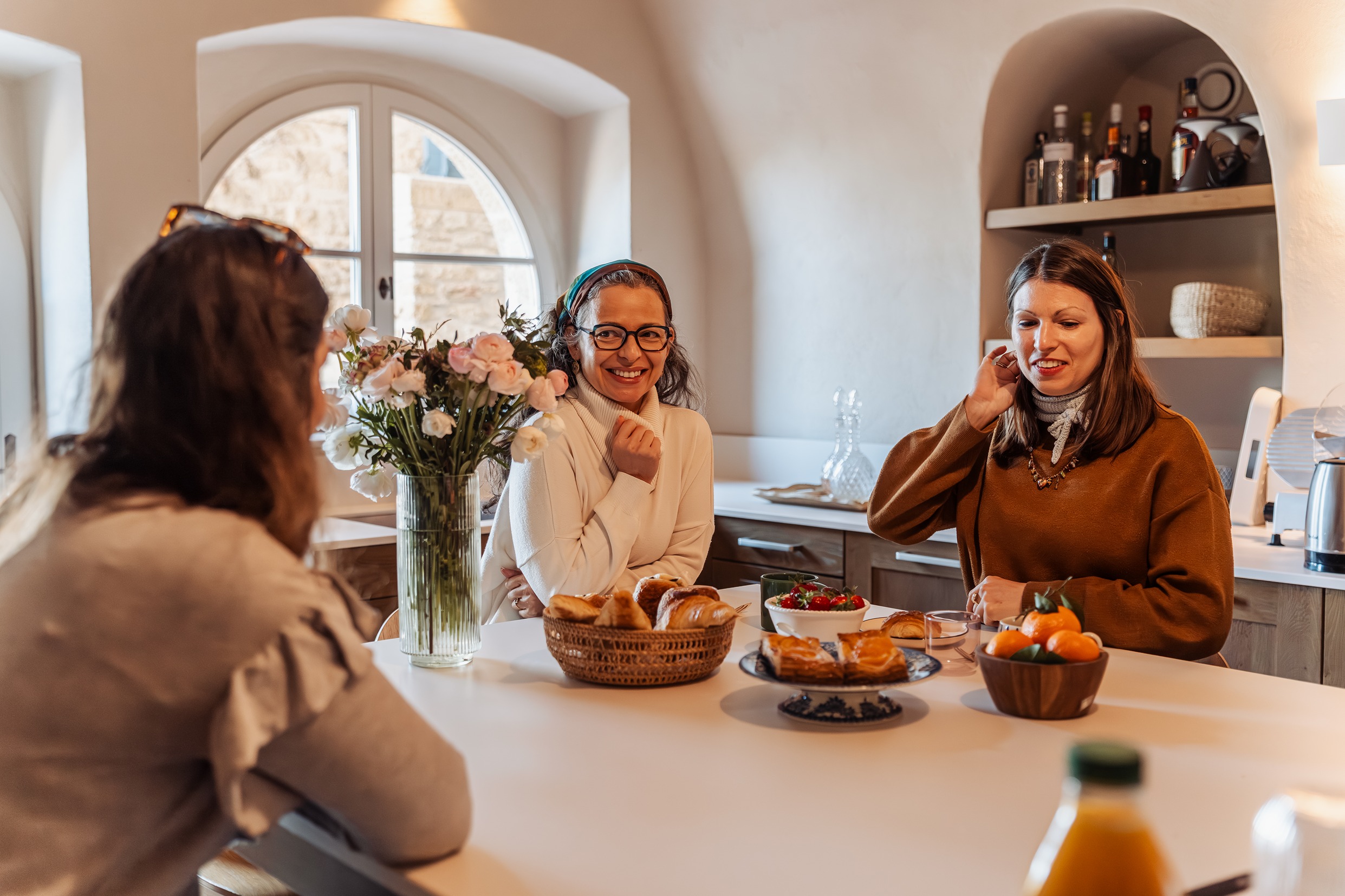 Women in the kitchen eating and enjoying themselves.